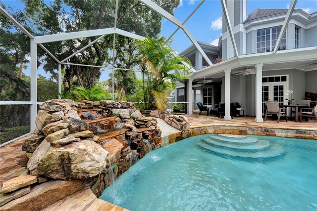 view of pool with ceiling fan, a lanai, a patio, and pool water feature