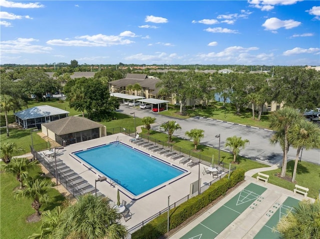 community pool featuring shuffleboard, a patio area, and fence