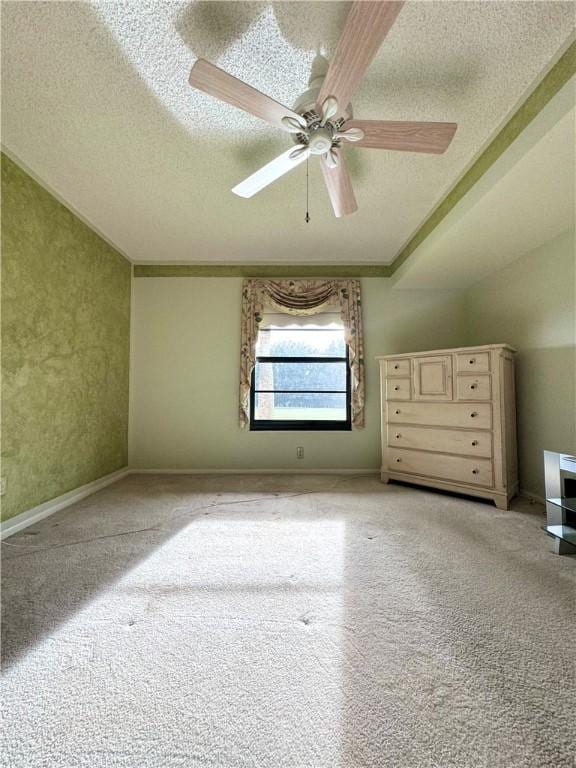 additional living space featuring baseboards, a ceiling fan, and a textured ceiling