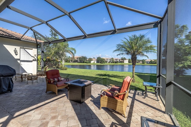 exterior space with glass enclosure, a water view, a fire pit, and a grill