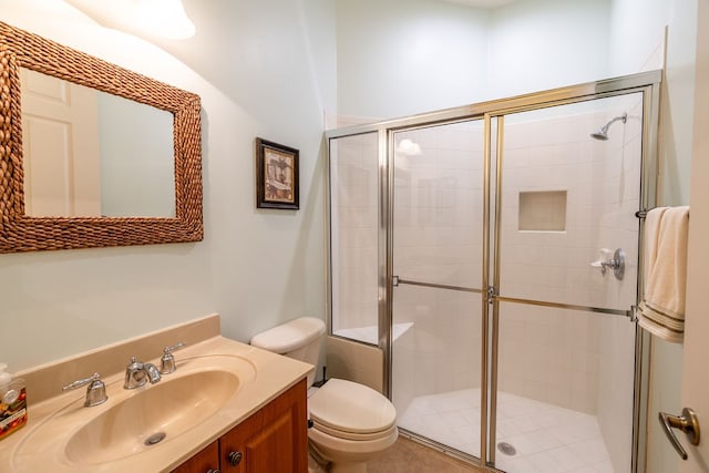 bathroom featuring a shower with door, vanity, and toilet