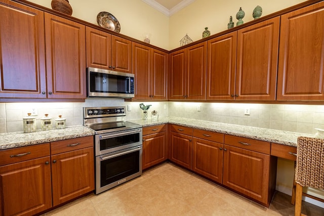 kitchen with ornamental molding, stainless steel appliances, tasteful backsplash, and light stone countertops