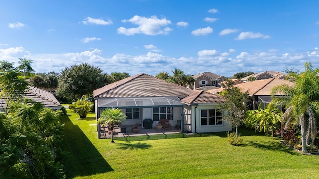 back of house with a lanai, a lawn, and a patio area