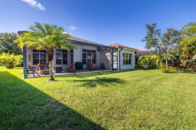 back of house featuring a patio area and a lawn