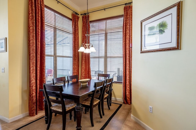 dining space with light tile patterned floors, a healthy amount of sunlight, and crown molding