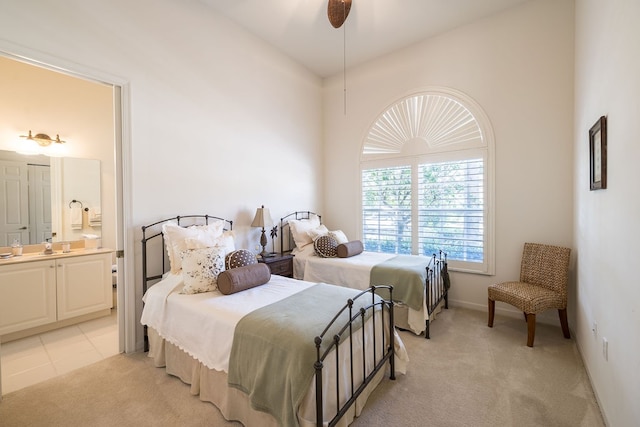 carpeted bedroom with ensuite bath and ceiling fan