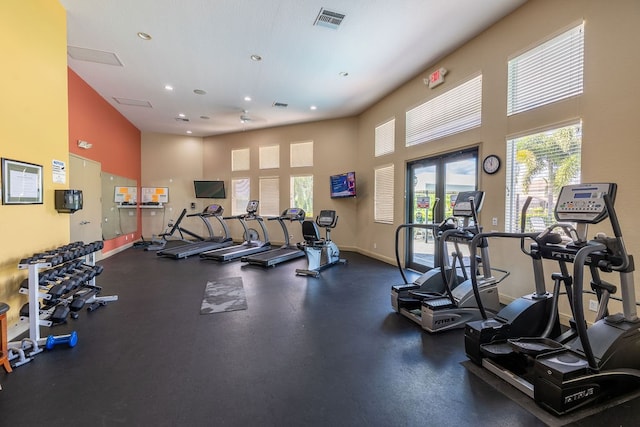 workout area featuring a towering ceiling