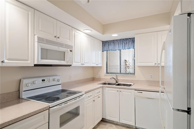 kitchen with light tile patterned floors, sink, white appliances, and white cabinets