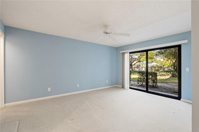 carpeted spare room with a textured ceiling and ceiling fan