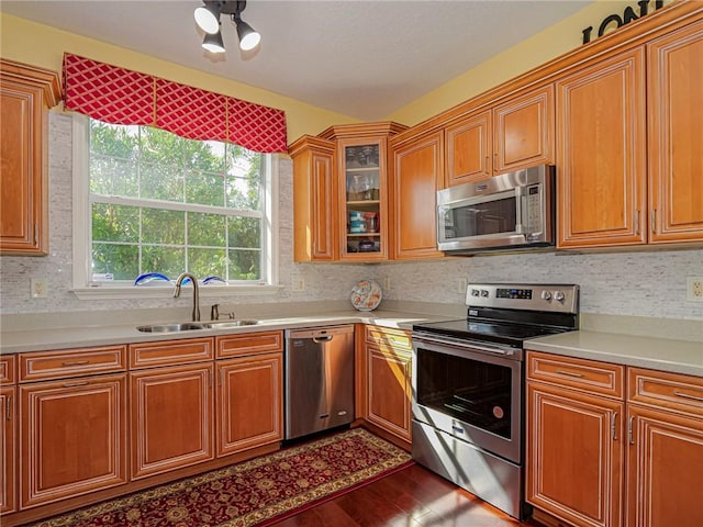 kitchen with light countertops, a sink, stainless steel appliances, and brown cabinets