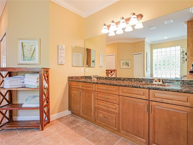 bathroom with crown molding, baseboards, a sink, visible vents, and double vanity