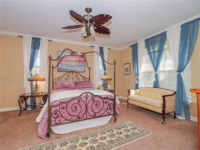 carpeted bedroom featuring baseboards, a textured ceiling, ceiling fan, and crown molding