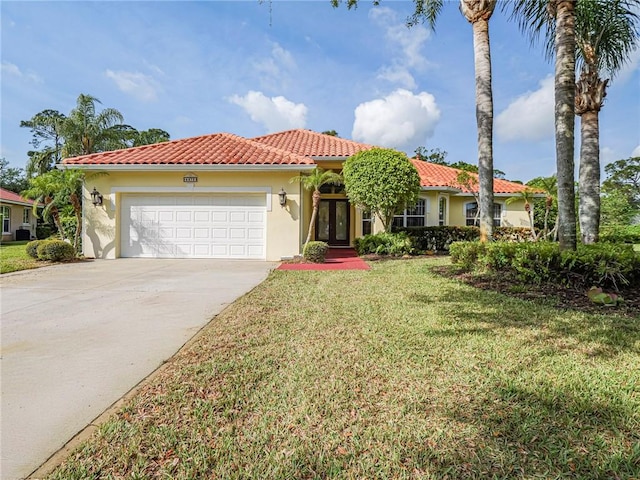 mediterranean / spanish home featuring a garage, stucco siding, a front yard, a tile roof, and driveway