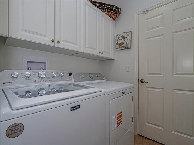 washroom featuring cabinet space and washer and clothes dryer