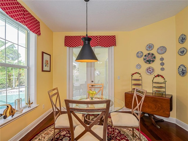 dining area with baseboards and wood finished floors