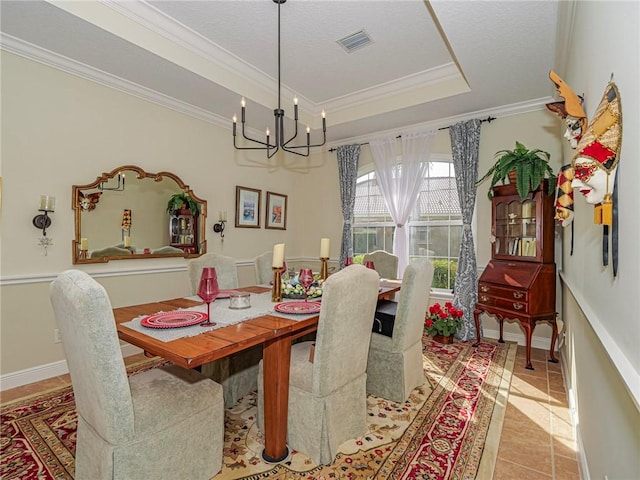dining space with a notable chandelier, a raised ceiling, light tile patterned floors, visible vents, and ornamental molding