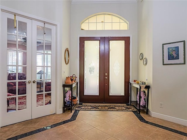 foyer featuring baseboards, french doors, and tile patterned floors