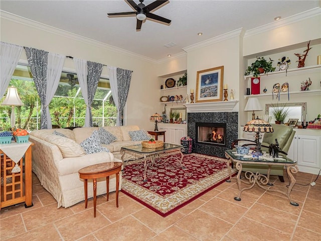 living area featuring built in features, ornamental molding, a fireplace, and a ceiling fan