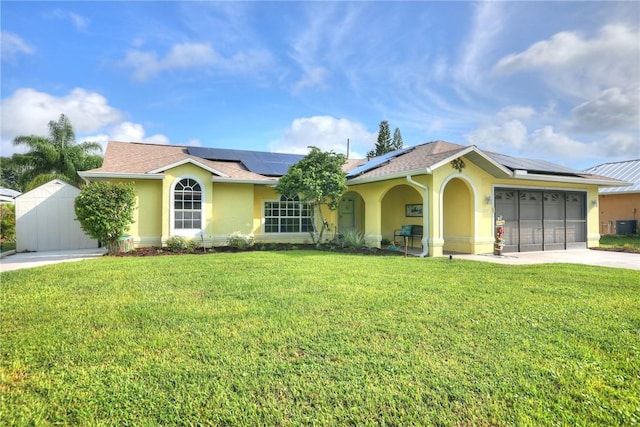 ranch-style house featuring a garage, solar panels, and a front yard