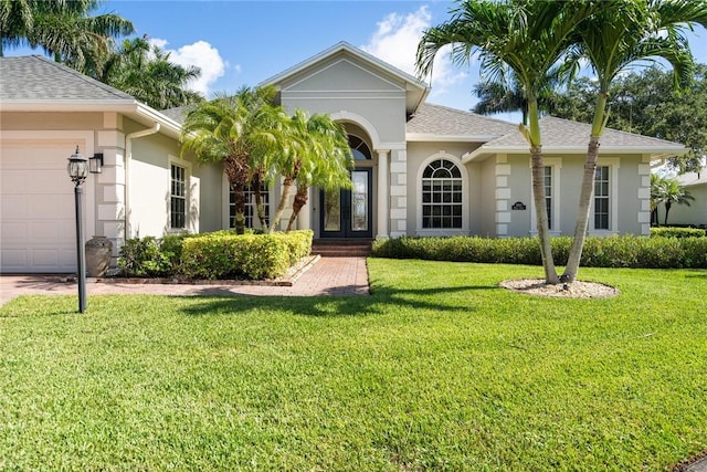 ranch-style house with stucco siding, a front yard, and french doors