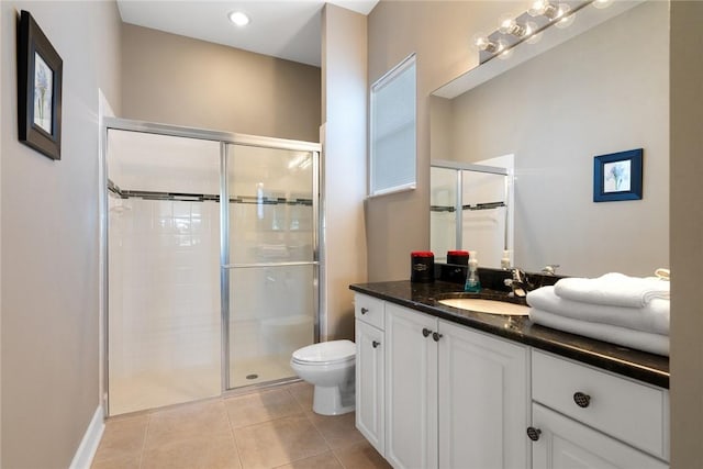 bathroom with vanity, a shower stall, toilet, and tile patterned floors