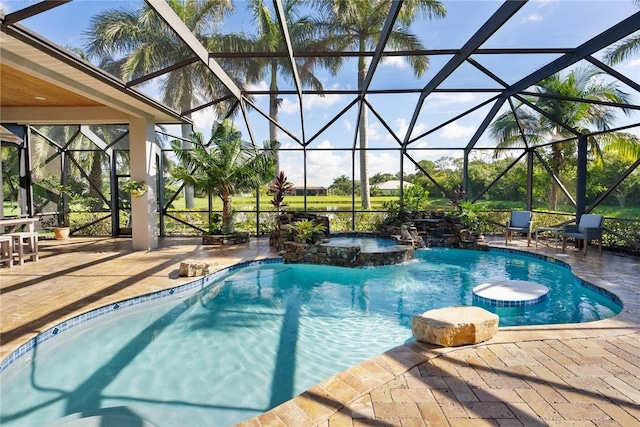 view of swimming pool featuring glass enclosure, a pool with connected hot tub, and a patio area