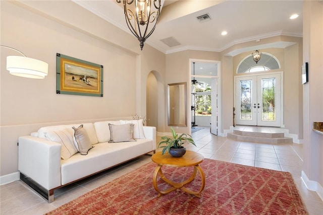 living room with arched walkways, a notable chandelier, french doors, and light tile patterned floors