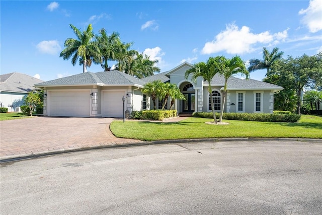 single story home with a garage, decorative driveway, and a front lawn