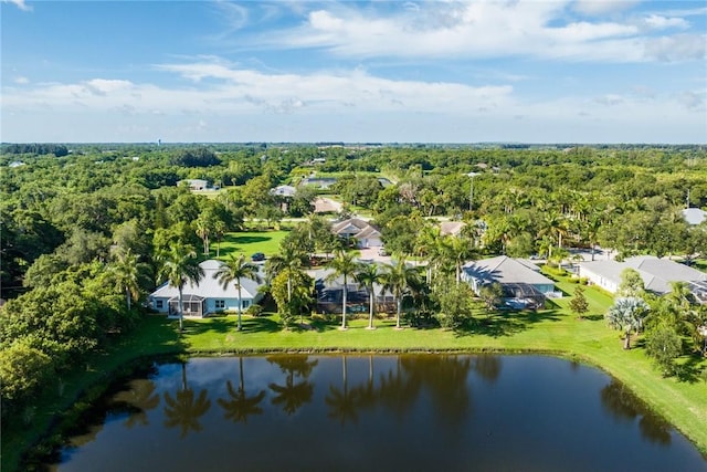 birds eye view of property with a water view and a wooded view