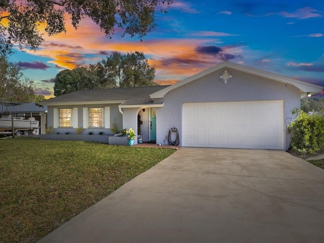 ranch-style house with a yard and a garage