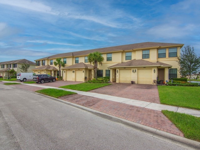 townhome / multi-family property with a garage and a front yard