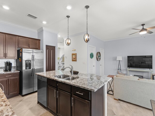 kitchen featuring black dishwasher, dark brown cabinetry, sink, a kitchen island with sink, and stainless steel fridge