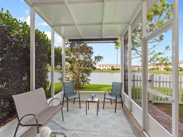 sunroom / solarium with a water view and a healthy amount of sunlight