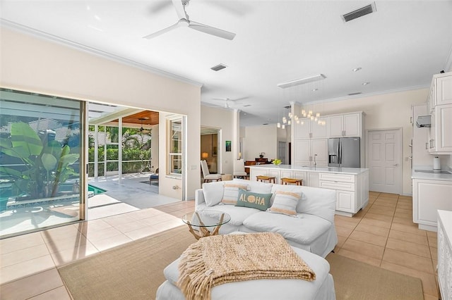 living room featuring ceiling fan, visible vents, ornamental molding, and light tile patterned floors