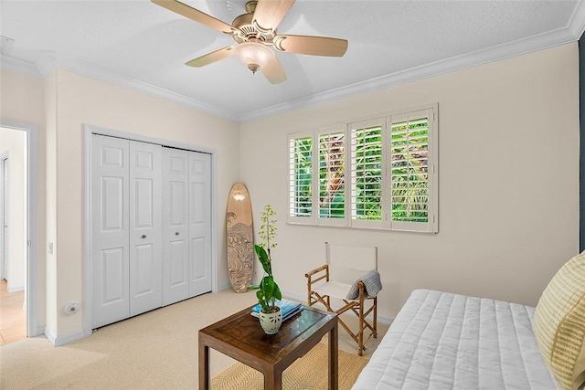 bedroom featuring carpet floors, ornamental molding, a ceiling fan, and a closet