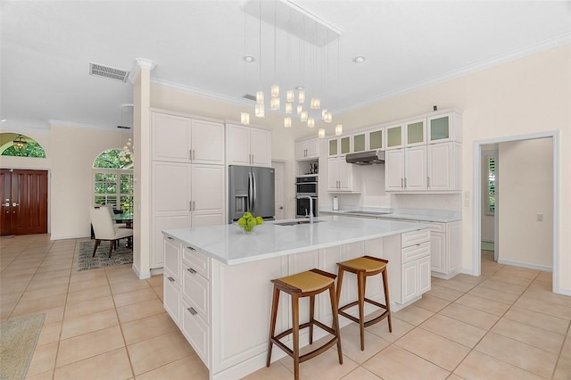 kitchen featuring under cabinet range hood, appliances with stainless steel finishes, light tile patterned floors, and visible vents