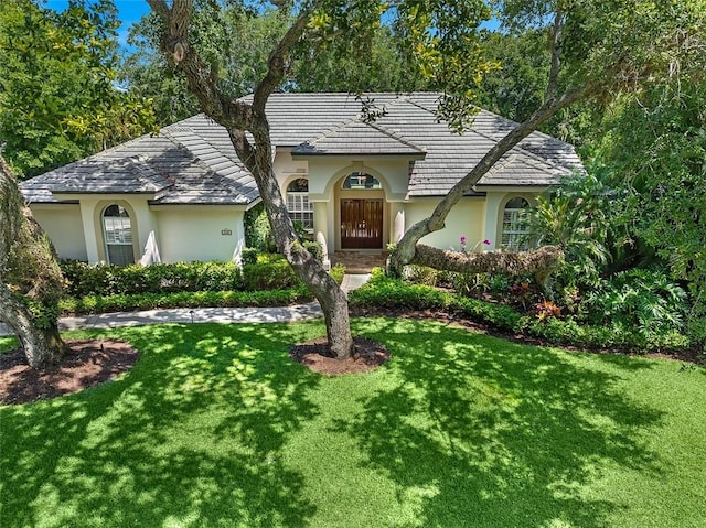 mediterranean / spanish home with stucco siding and a front yard