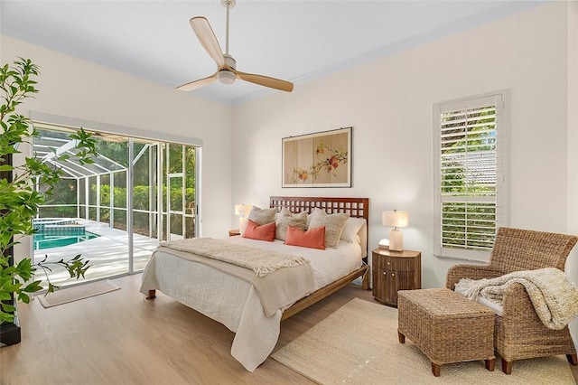 bedroom with access to outside, wood finished floors, and multiple windows