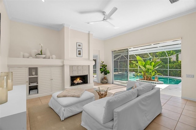 tiled living area featuring crown molding, a ceiling fan, a warm lit fireplace, and a sunroom