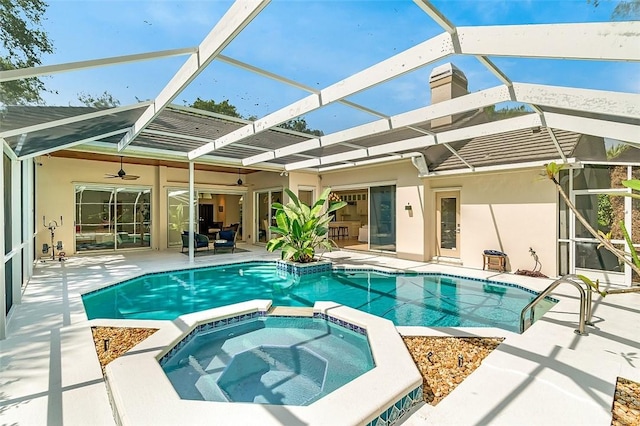 view of pool with glass enclosure, a pool with connected hot tub, and a patio area