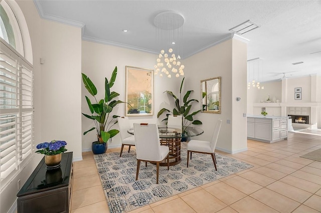 dining room with light tile patterned floors, baseboards, ornamental molding, and a fireplace