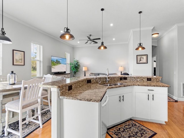 kitchen featuring white cabinets, decorative light fixtures, and sink