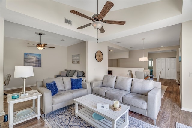 living room featuring dark wood-type flooring and ceiling fan