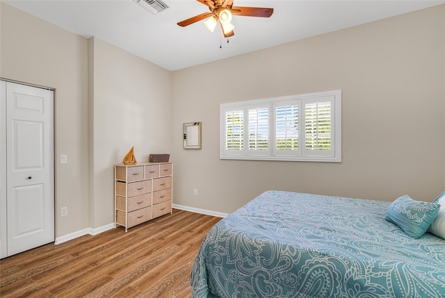 bedroom featuring ceiling fan, wood-type flooring, and a closet