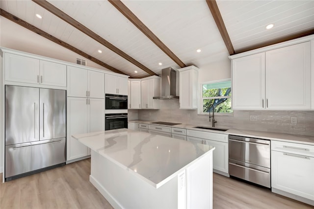 kitchen with black appliances, sink, wall chimney exhaust hood, vaulted ceiling with beams, and a kitchen island