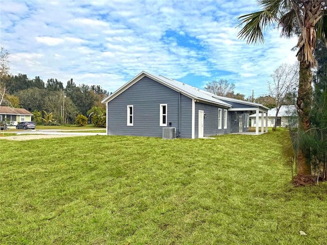 view of side of property featuring a lawn and central AC unit