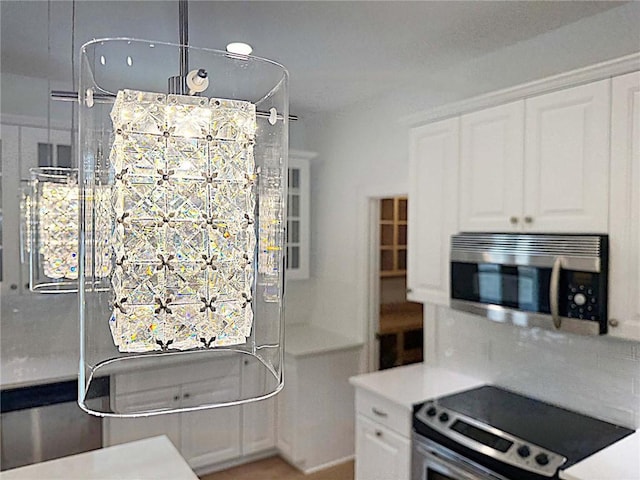 kitchen featuring white cabinets, decorative backsplash, and appliances with stainless steel finishes