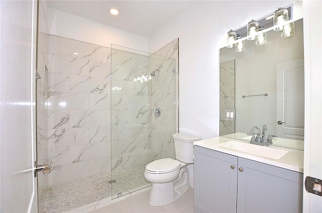 bathroom with tile patterned flooring, a tile shower, vanity, and toilet