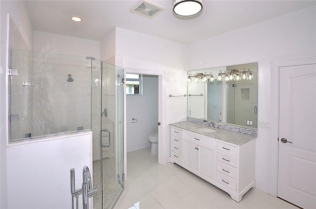 bathroom with toilet, a shower with door, tile patterned floors, and vanity