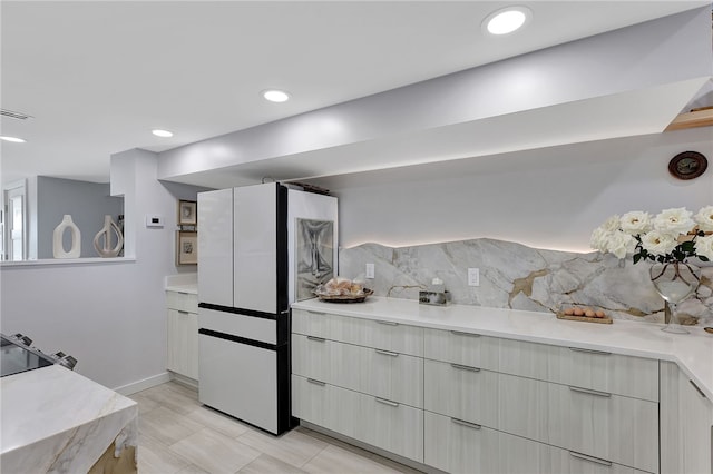 kitchen featuring backsplash, white refrigerator, and black range oven